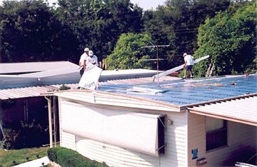 Two men are working on the roof of a house