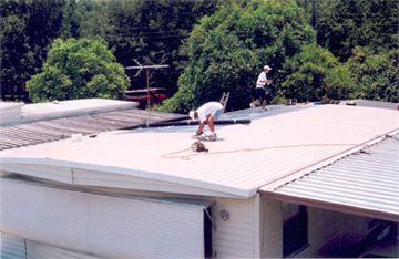 A man is working on the roof of a building.