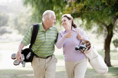 cheerful couple returning after playing golf