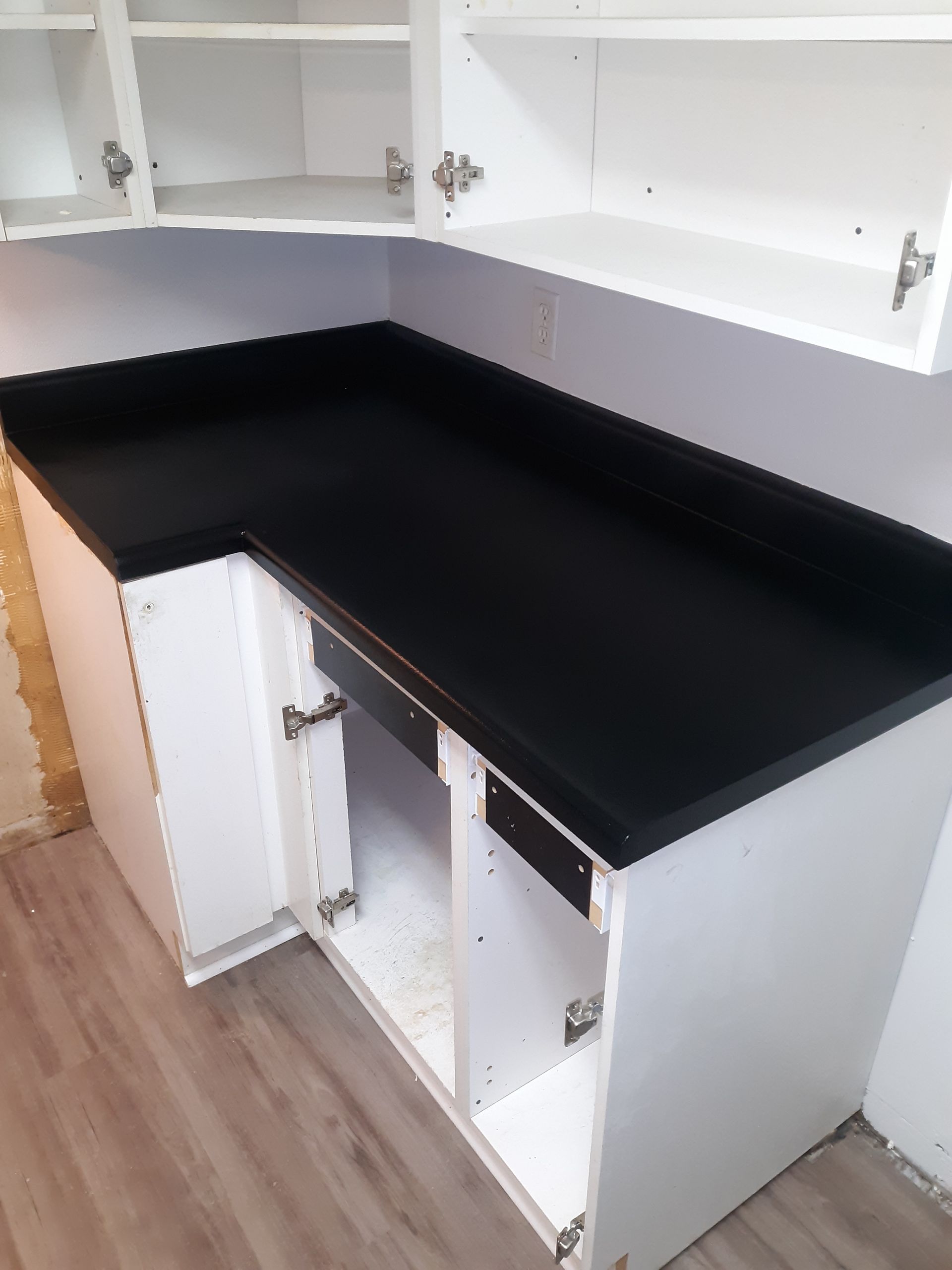 A kitchen with a black counter top and white cabinets