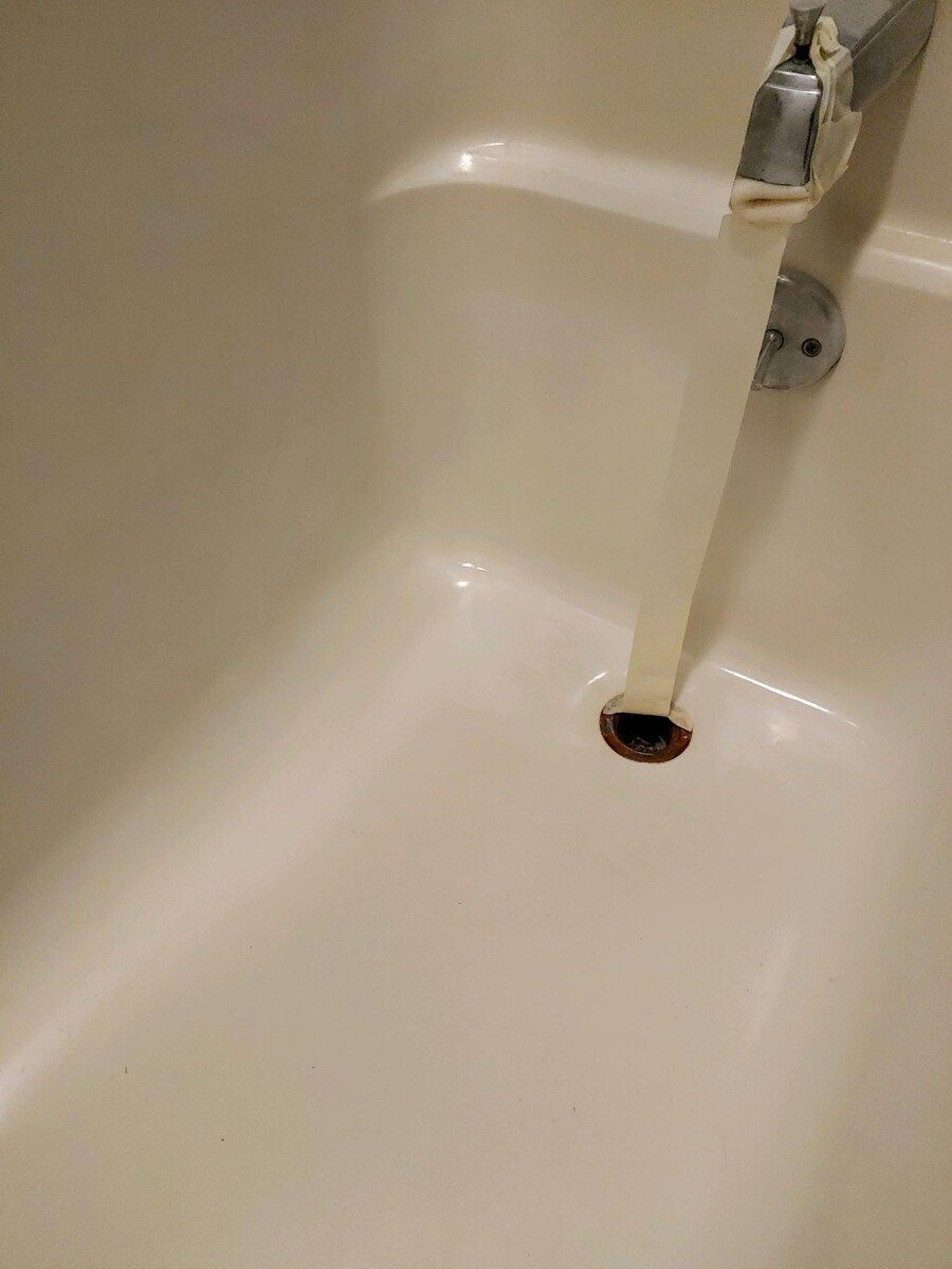 A white box is sitting on a concrete floor next to a white wall.