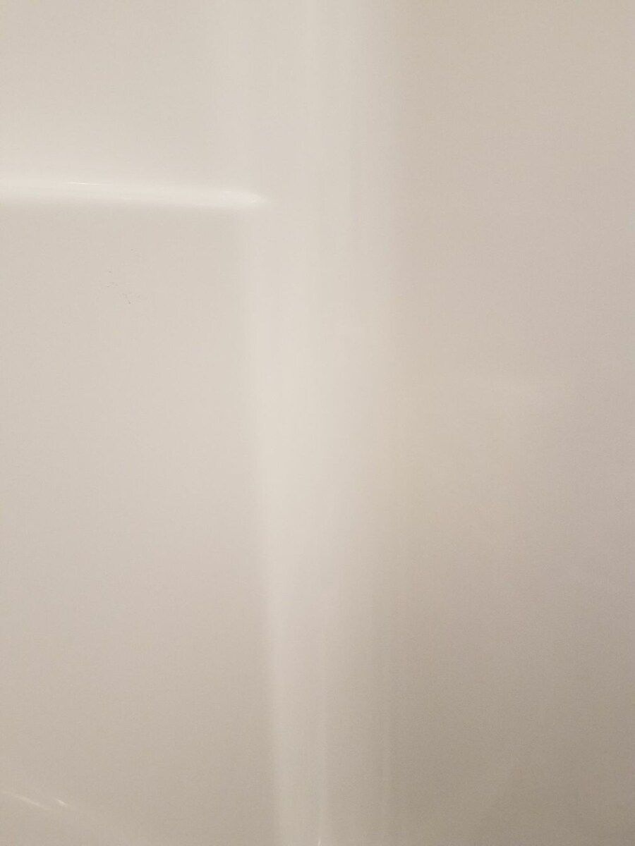 A close up of a white wall with a corner.