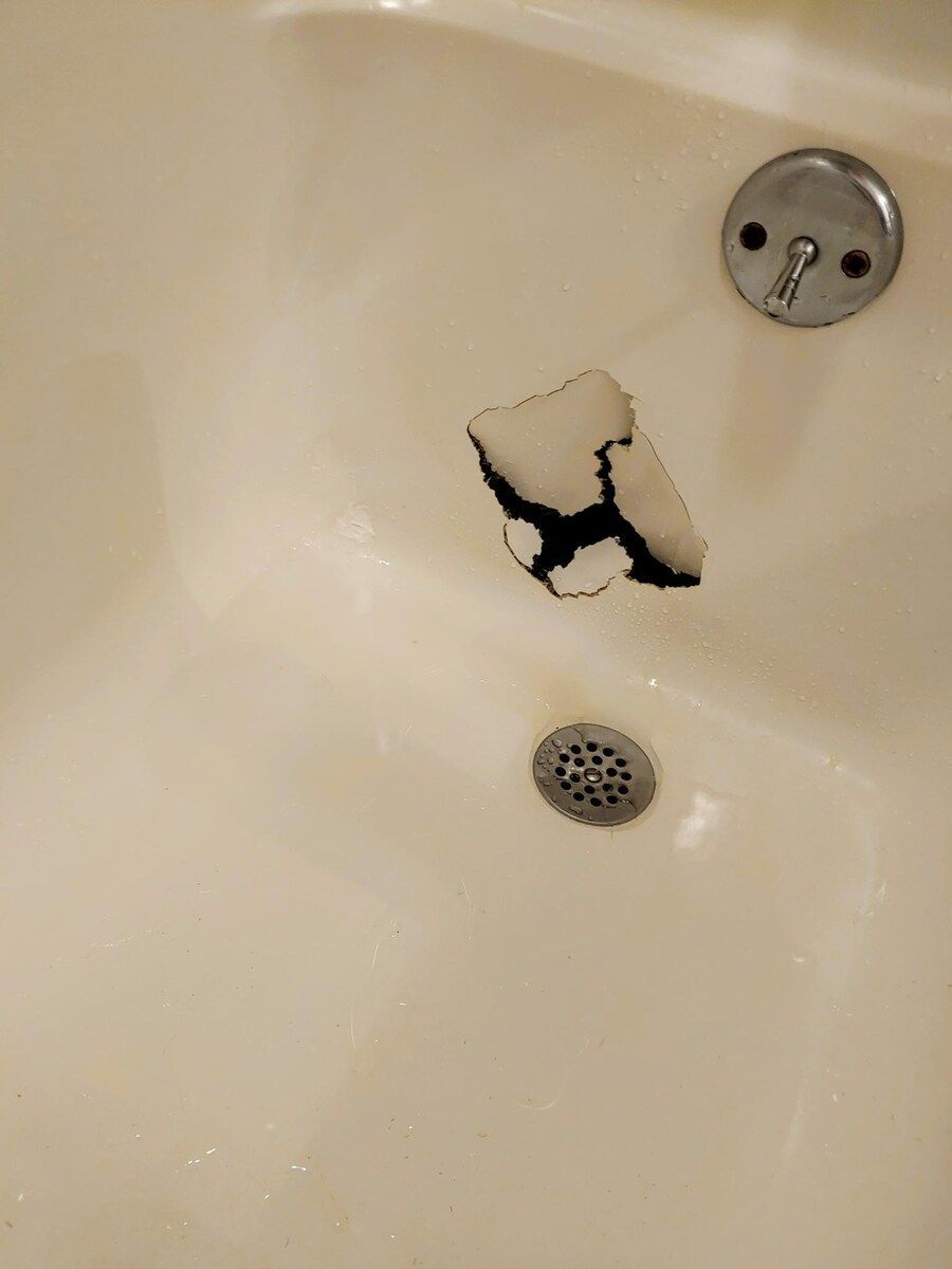 A white door is sitting on a red floor next to a piece of wood.