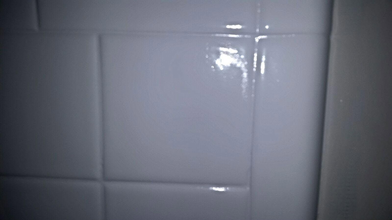 A blue bathtub is sitting in a bathroom next to a wall.