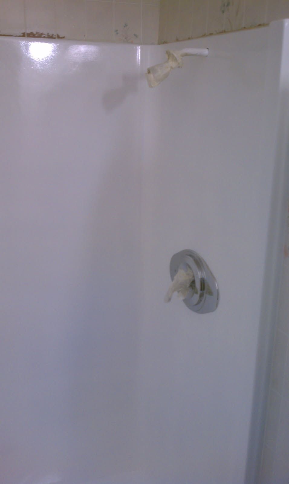 A white bathtub is sitting in a bathroom next to a tiled wall.