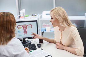 Obstetrics Services — Doctor Showing Female Reproductive System Diagram To Patient in Laredo, TX