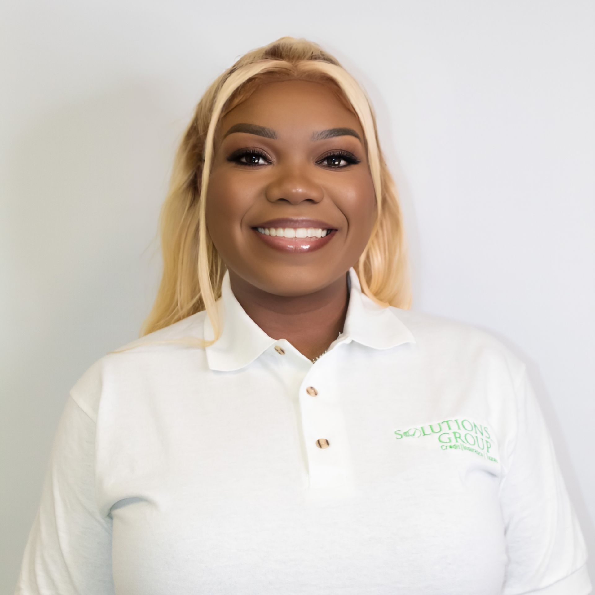 Woman with blonde hair wearing a white polo shirt with 