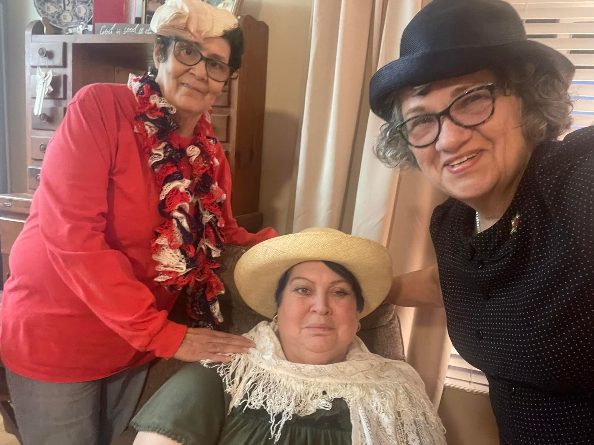 three ladies wearing hats at a tea party