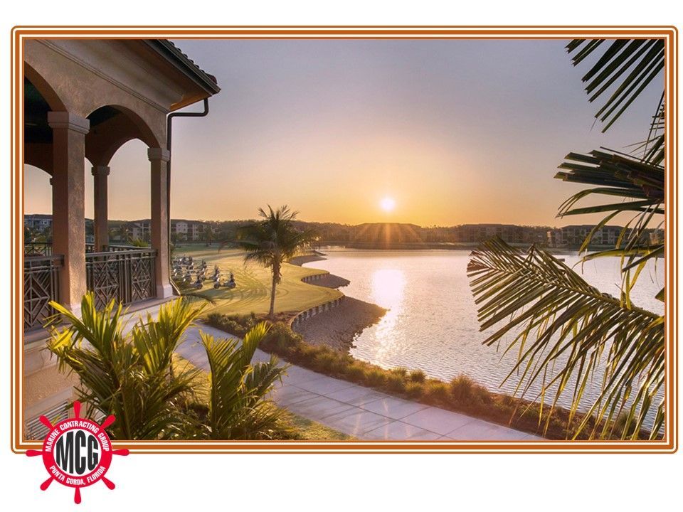 A picture of a sunset over a lake with palm trees - Punta Gorda, FL - Marine Contracting Group Inc