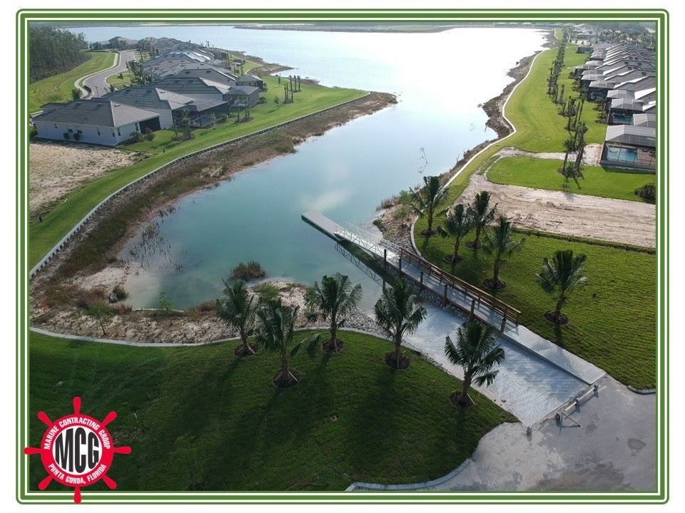 An aerial view of a lake with a mcc logo in the corner - Punta Gorda, FL - Marine Contracting Group Inc