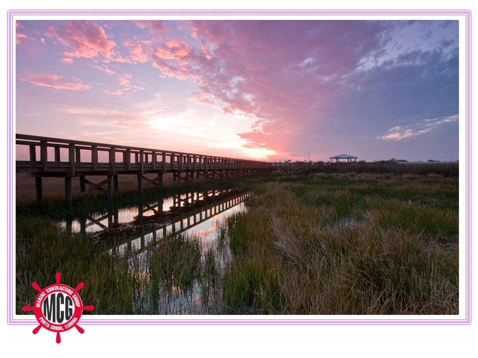 A wooden bridge over a body of water at sunset - Punta Gorda, FL - Marine Contracting Group Inc