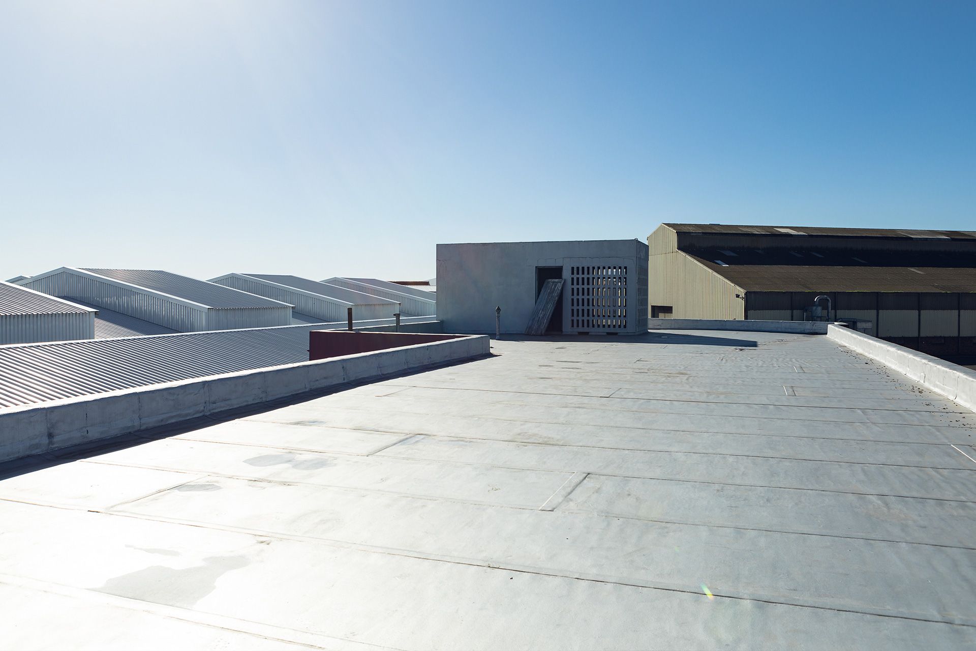 commercial roof inspector checking large business building roof for damage and leaks
