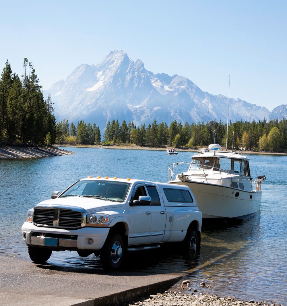 Pick Up Truck In Front Of A Boat — Ogden, UT — Sam T Evans Pickup Cover & Trailer Sales