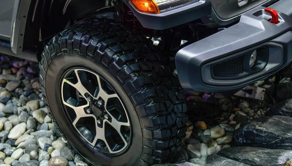 A Close Up of a Jeep 's Tire on a Rocky Surface — Precise Detailing Specialists in Emerald, QLD