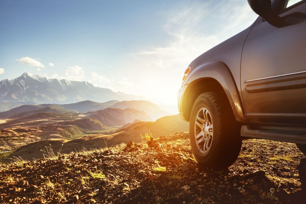 A Car is Parked on Top of a Rocky Hill With Mountains in the Background — Precise Detailing Specialists in Emerald, QLD