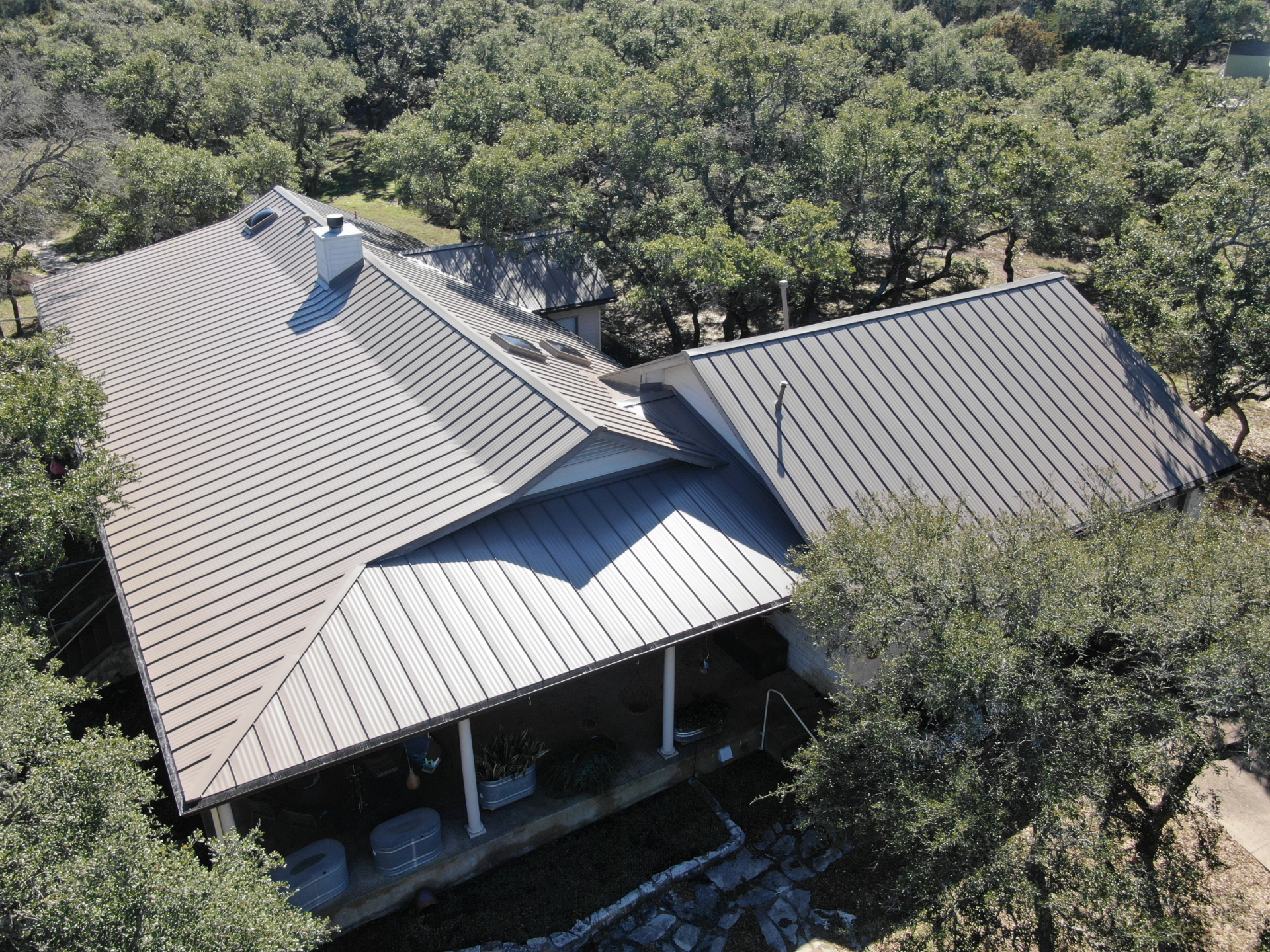An aerial view of a house with a metal roof