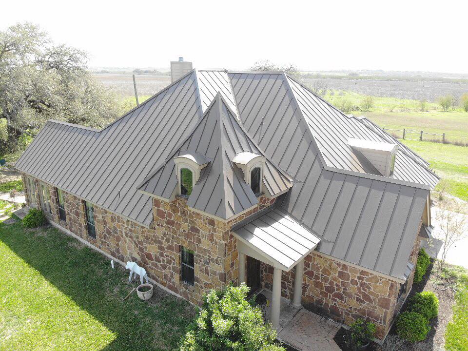 An aerial view of a large house with a metal roof.