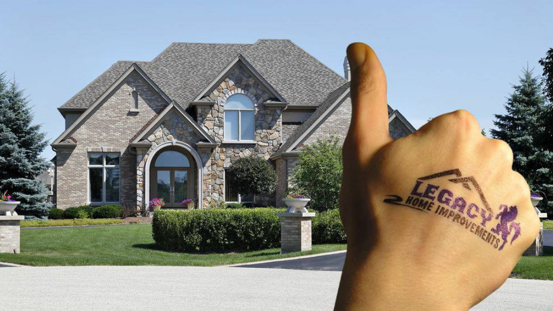 A hand with the word legacy on it is giving a thumbs up in front of a house