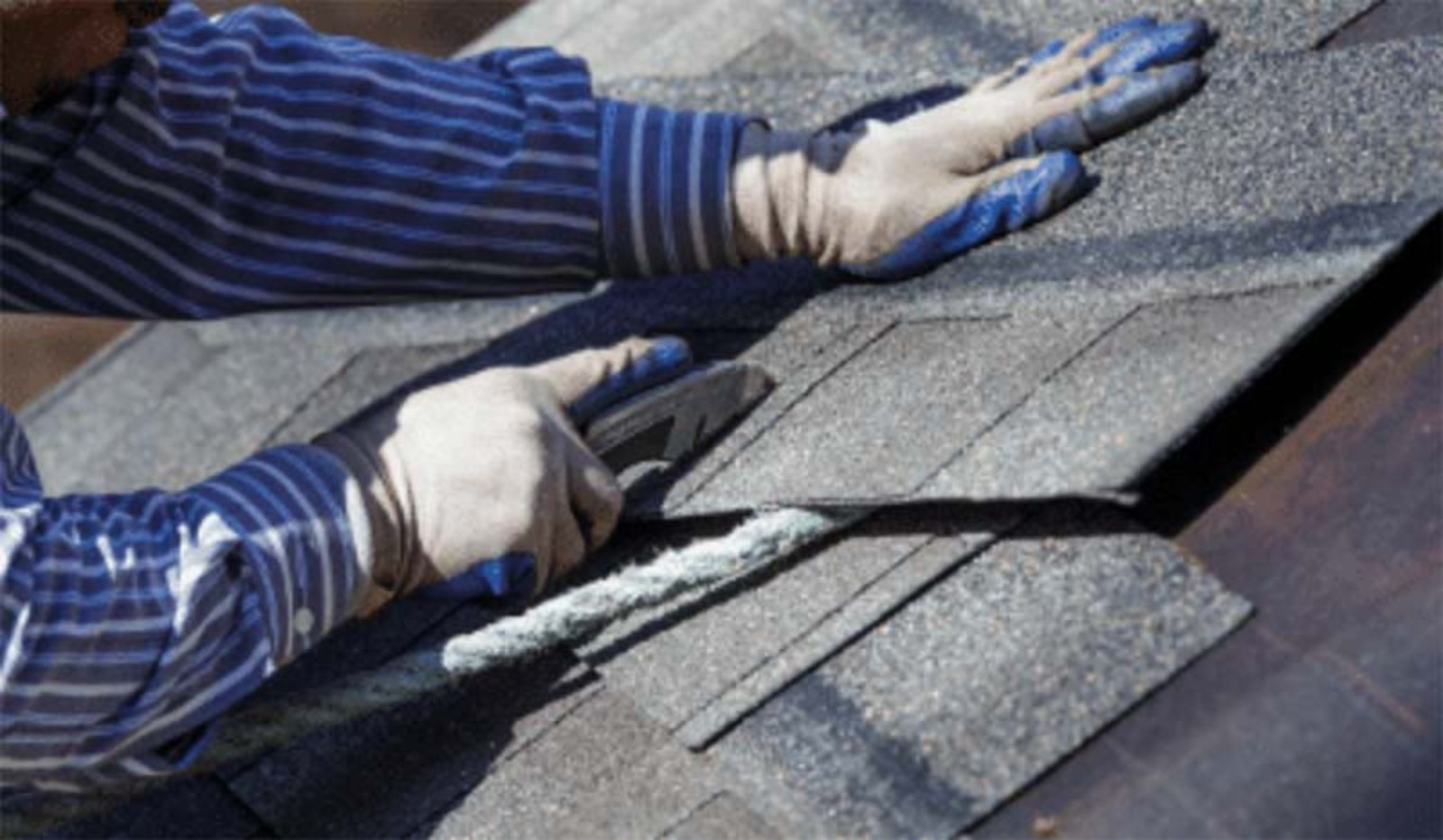A man is working on a roof with a pair of pliers.