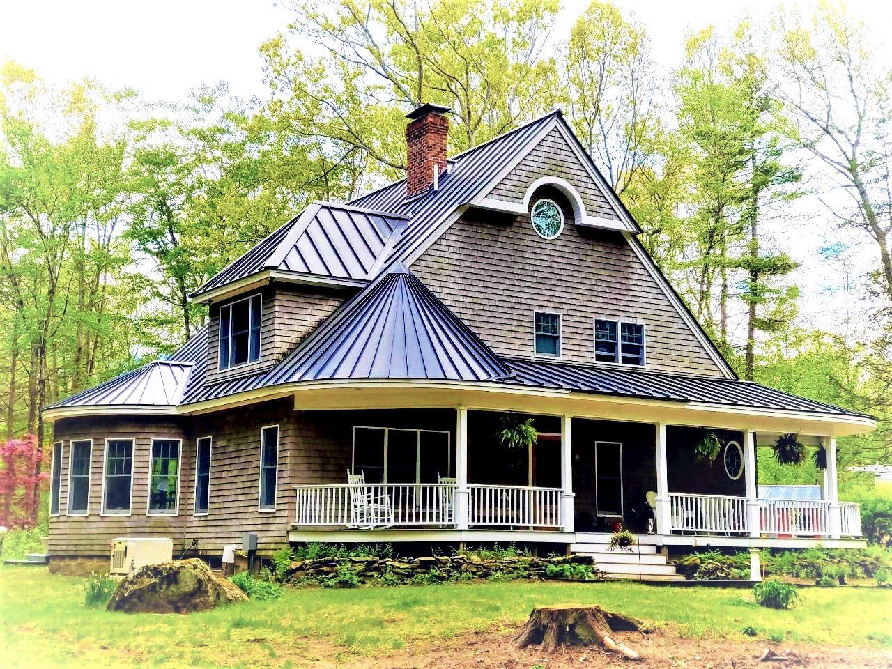 A large house with a porch and a blue roof