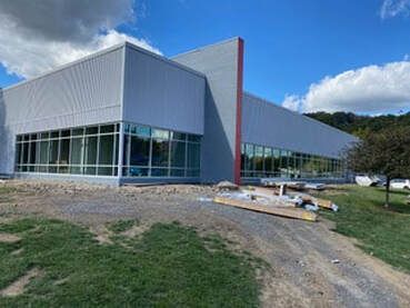 A large white building with a lot of windows is being built.