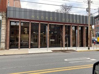 A large building with a lot of windows is on the side of the road.