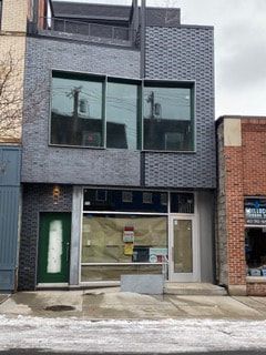 A building with a lot of windows and a door on a street.