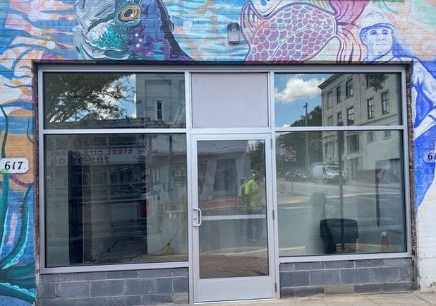 An empty store front with a mural on the side of it.