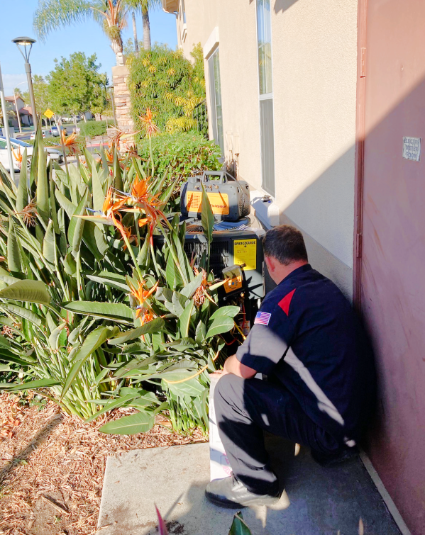 A man is kneeling down in front of a building