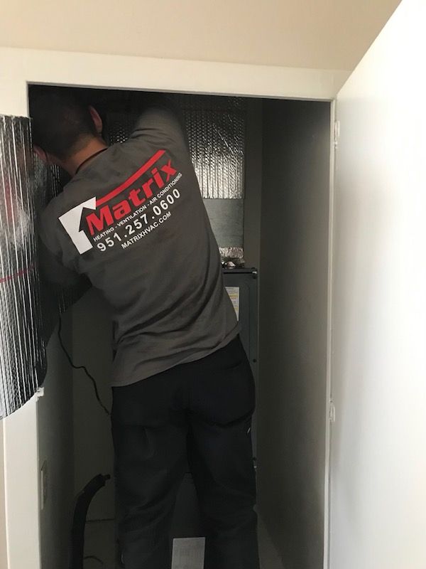 A man wearing a matrix shirt is standing in a doorway