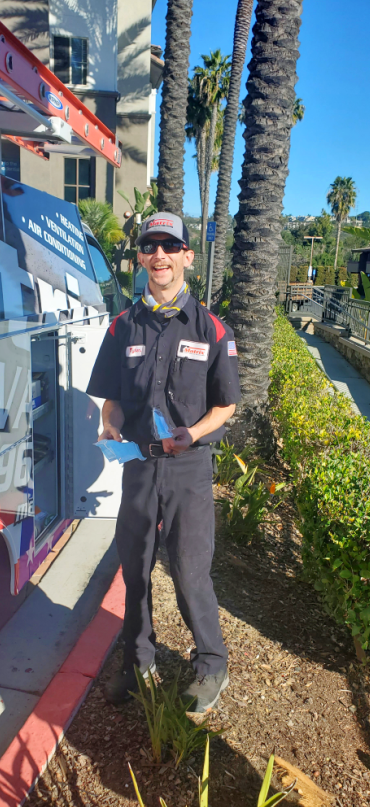 A man in a uniform is standing in front of a building.