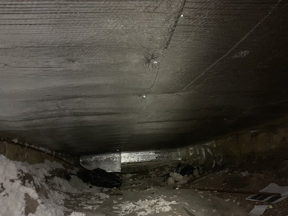 A dark room with a lot of snow on the ground and a ceiling.