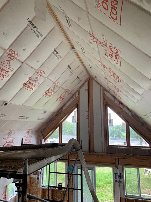 A room with a ceiling that is covered in insulation and a lot of windows.