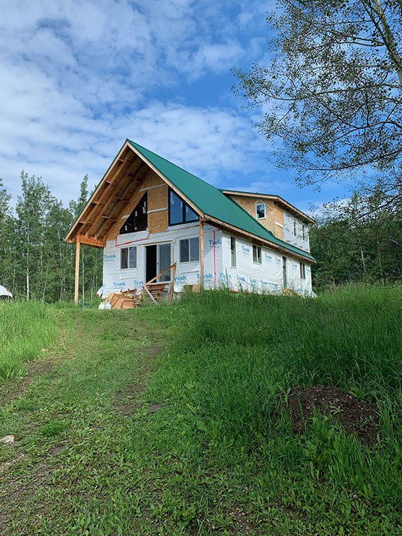 A house is being built in the middle of a grassy field.