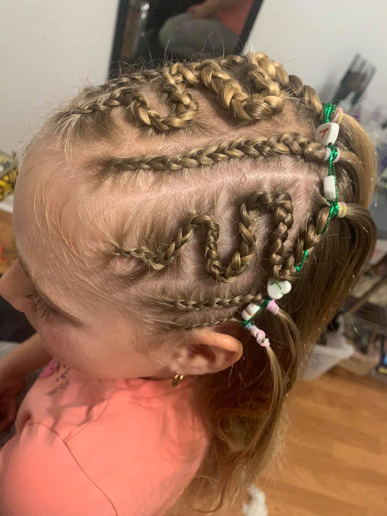 A little girl with braids and beads in her hair.