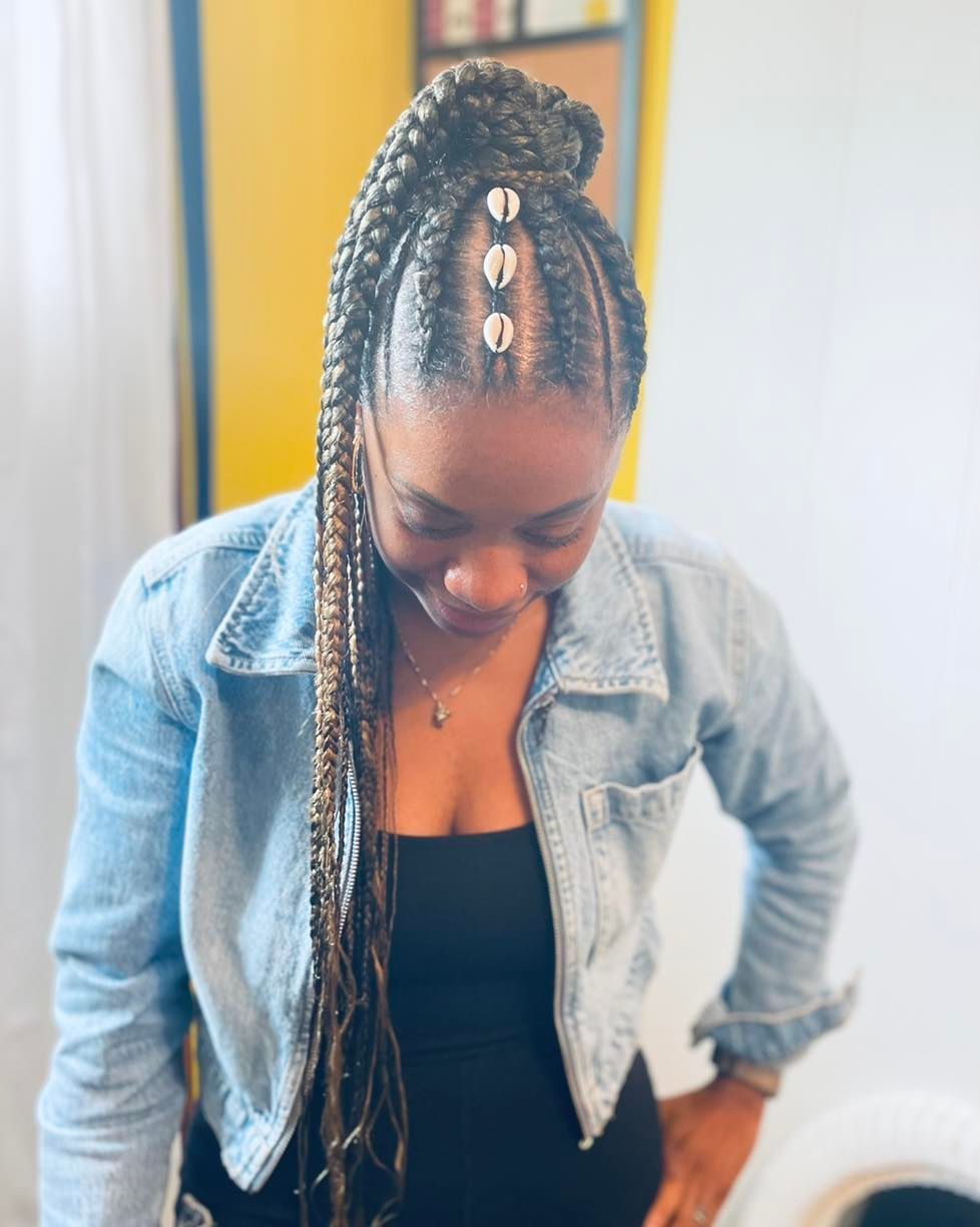 The woman is wearing a denim jacket and a black tank top.