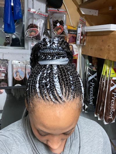 A woman with braids in her hair is standing in a store.