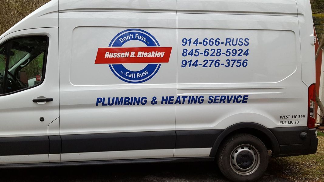 A white van with plumbing and heating service written on the side
