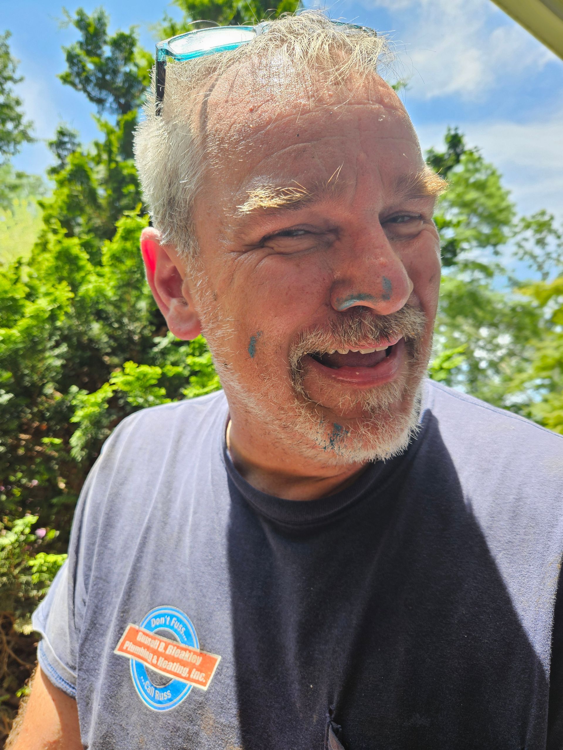 A plumber holding a red-tag gas-leak cards from the gas utility as he fixes gas leaks in front of the brick wall for our customers.