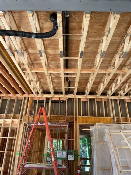 A ladder is sitting on top of a wooden scaffolding in a building under construction.