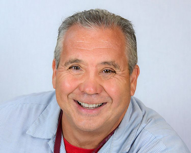 A man is smiling for the camera and wearing a stethoscope around his neck.