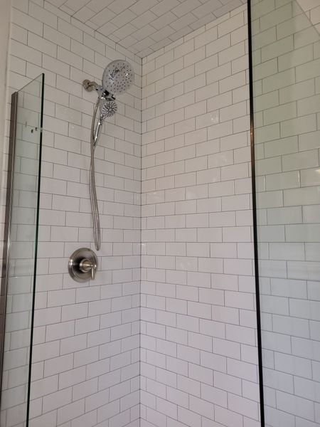 There is a shower head in the corner of the shower.