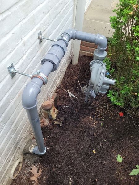 A pipe is attached to the side of a building.