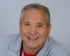 A man is smiling for the camera and wearing a stethoscope around his neck.