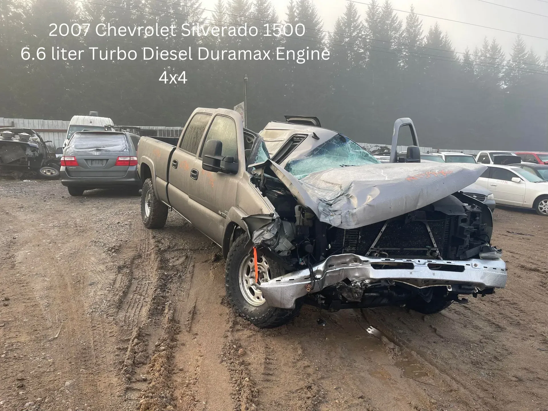 Damaged 2007 Chevy Silverado pickup truck at a salvage yard, front end heavily crushed.