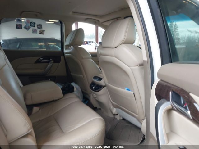 Tan leather interior of an Acura SUV, showing the rear seats, armrest, and door panel.