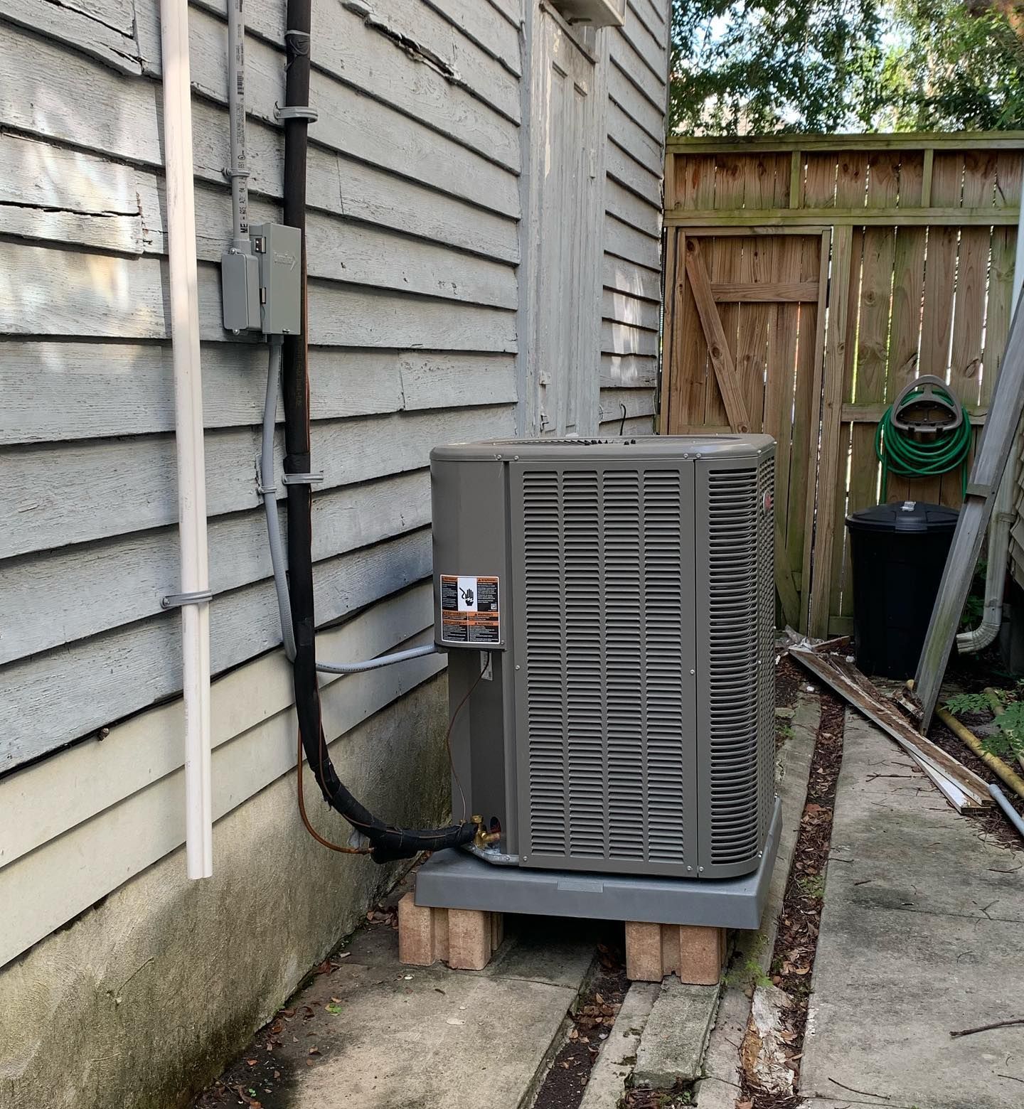 An air conditioner is attached to the side of a house