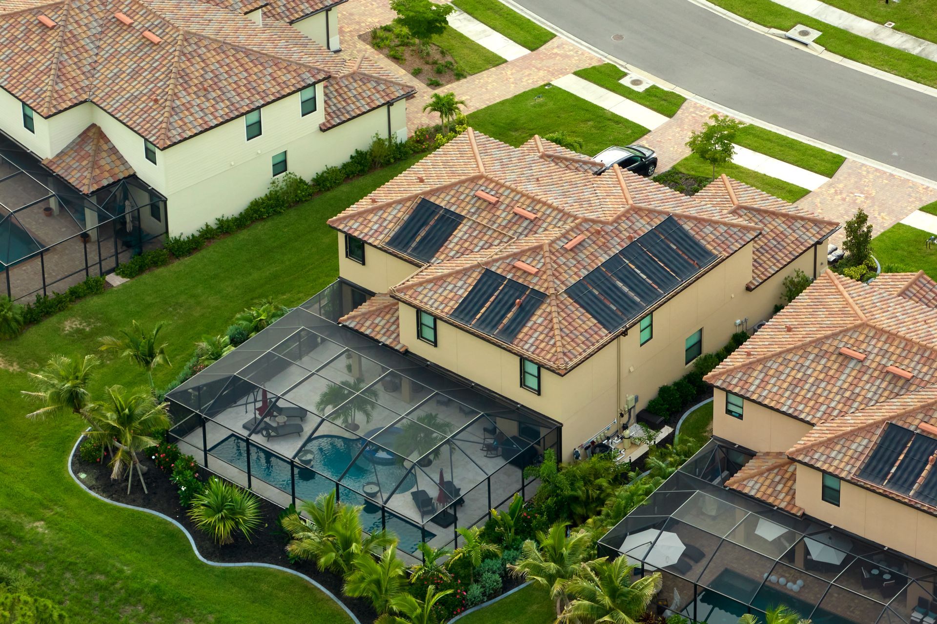 A large house with a lot of windows and balconies is sitting next to a smaller house.
