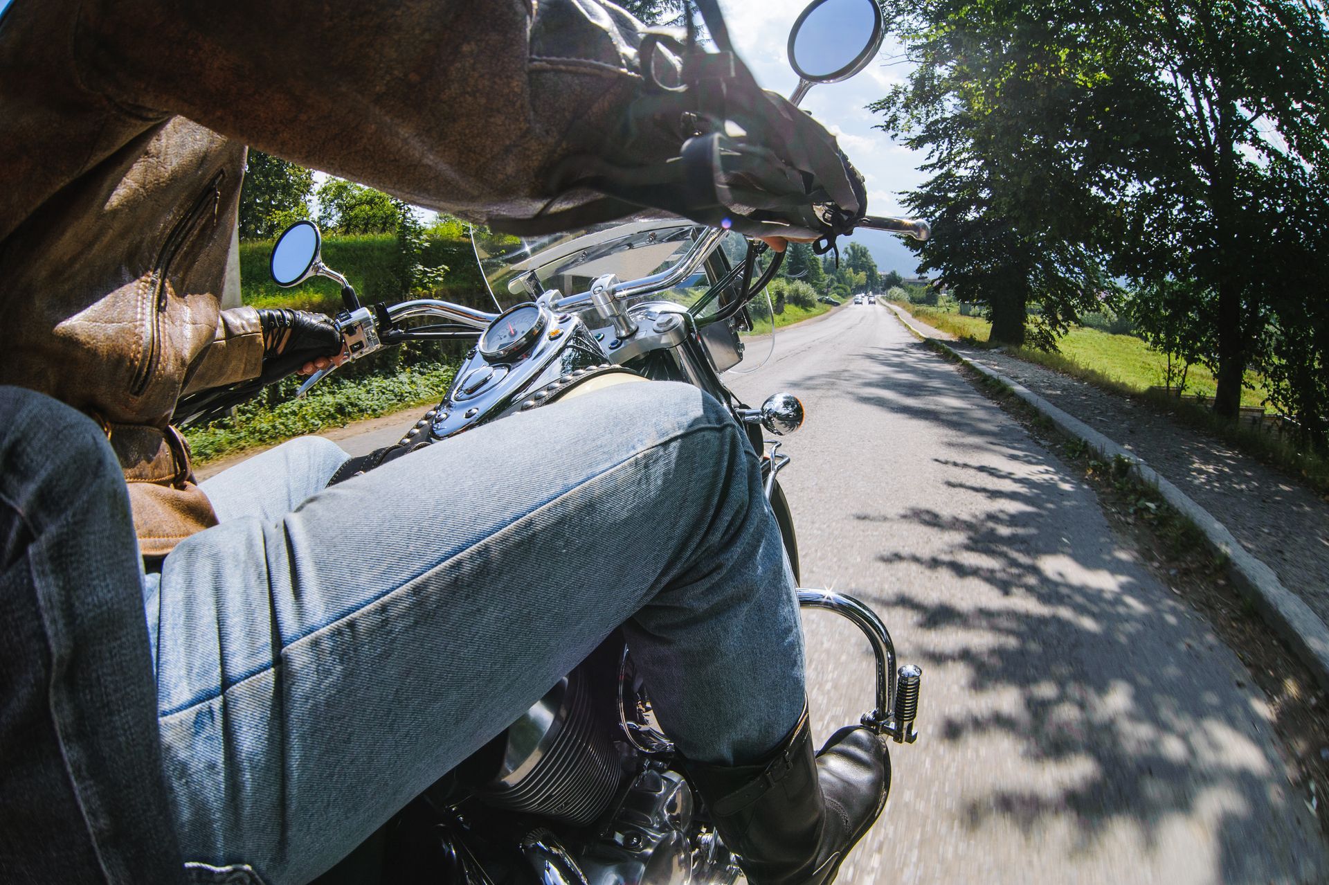 A person is riding a motorcycle down a mountain road.
