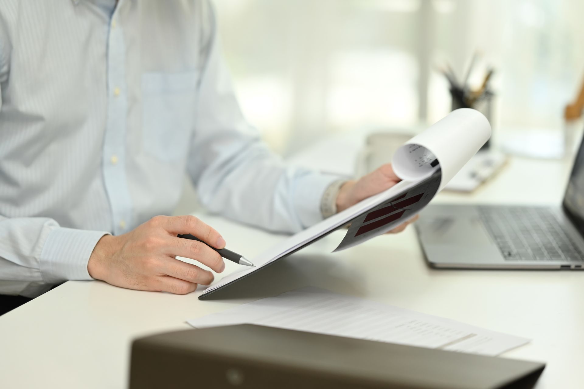 A man is sitting at a desk writing in a notebook.